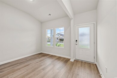 Foyer with lofted ceiling and light hardwood / woo