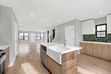 Kitchen featuring brown cabinetry, light wood-style flooring, plenty of natural light, light stone countertops, and recessed lighting