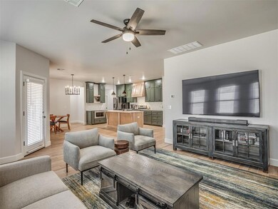 Living area with a chandelier, ceiling fan, and light wood-style flooring