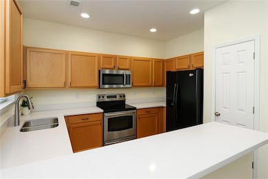 Kitchen with a sink, light countertops, a peninsul