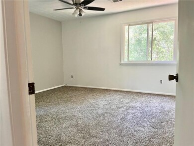 Empty room with carpet floors, a ceiling fan, and baseboards