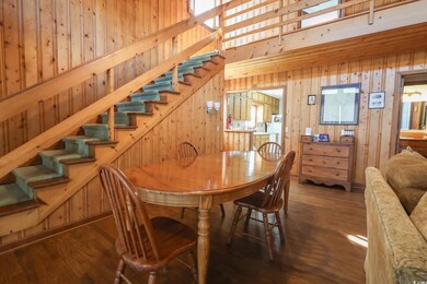 Dining room with stairs, wooden walls, and wood finished floors