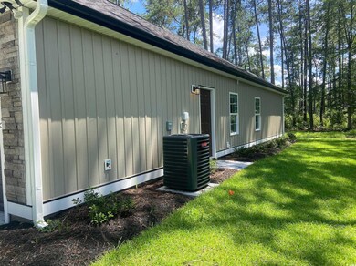 View of side of property with a yard and a shingled roof