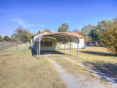 View of parking featuring driveway, a gate, and a detached carport