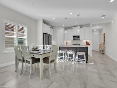 Dining room featuring recessed lighting and light marble finish floors