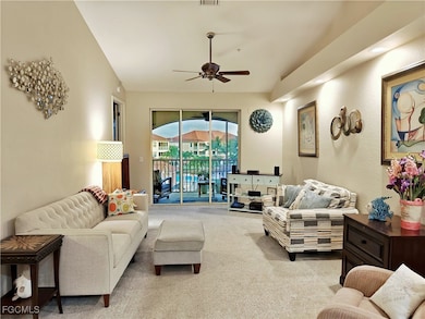 Carpeted living area featuring a ceiling fan
