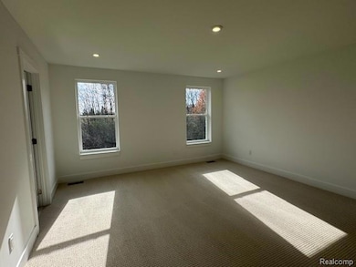 Carpeted spare room featuring plenty of natural light and recessed lighting