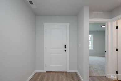 Entryway featuring baseboards and wood finished floors