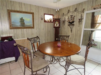 Dining room /family room has paneling, tile floor,