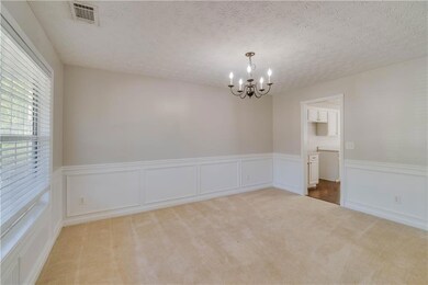 Empty room featuring a wainscoted wall, carpet flo