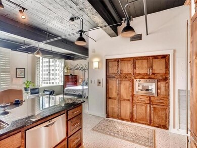 Kitchen with dark speckled floor, brown cabinets,