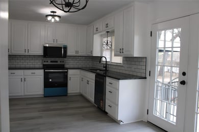 Kitchen featuring a sink, dishwashing machine, sta