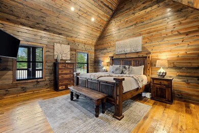Bedroom with wood walls, hardwood / wood-style flooring, wood ceiling, and high vaulted ceiling