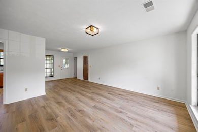 Unfurnished living room with wood finished floors and baseboards