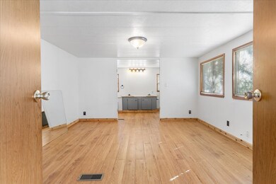 Unfurnished room featuring light wood finished floors and baseboards