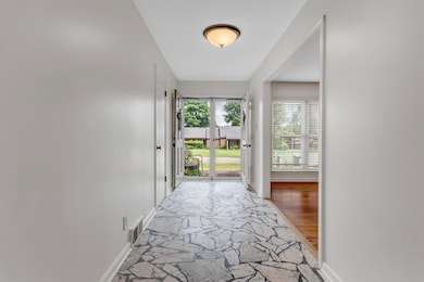 Hallway with stone flooring and baseboards