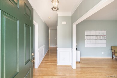 Wood floored foyer featuring ornamental molding