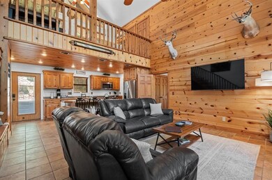 Living room with wooden walls, light tile patterned flooring, and a towering ceiling