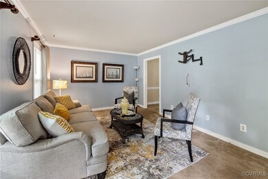 Carpeted living room featuring crown molding