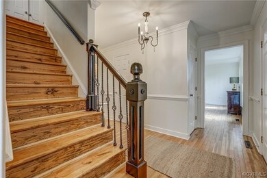 Staircase featuring a notable chandelier, crown mo