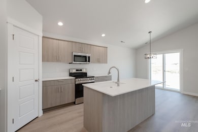 Kitchen featuring stainless steel appliances, light brown cabinetry, pendant lighting, light wood finished floors, and recessed lighting