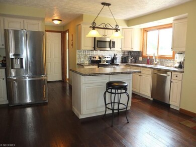 Open kitchen has an island with breakfast bar.