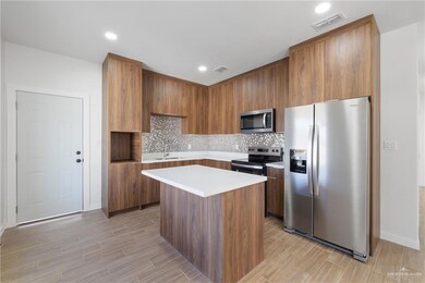 Kitchen featuring stainless steel appliances, modern cabinets, brown cabinets, a kitchen island, and tasteful backsplash