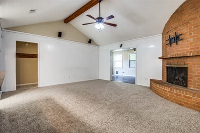 Soaring ceiling with wooden beam and brick fireplace adds character to the living room.