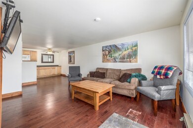 Living room with ceiling fan, dark wood-type floor