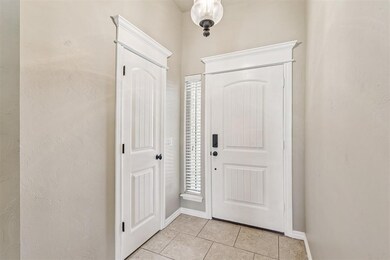 Entrance foyer with light tile patterned floors and baseboards