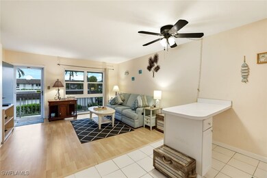 Living room featuring a ceiling fan, light wood-st