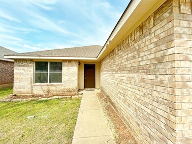 Property entrance featuring brick siding and roof 