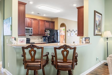 Kitchen with a kitchen bar, black appliances, and 