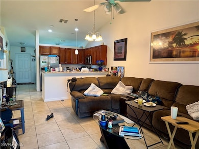 Living room with ceiling fan, light tile patterned