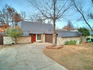 View of front of house with stone siding, concrete