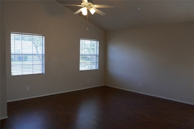 Family room has warm laminate flooring, vaulted ceiling.