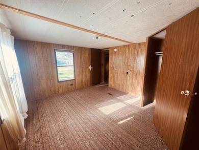 Spare room with carpet and wood walls