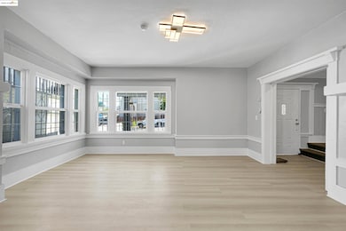 Empty room with light wood finished floors and baseboards