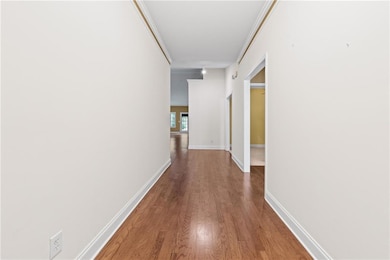 Hall featuring dark wood-type flooring and baseboards