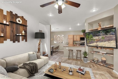 Living area with ceiling fan, baseboards, and rece