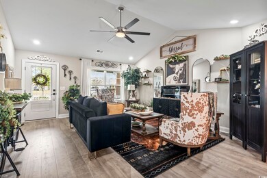 Living room featuring vaulted ceiling, hardwood / 