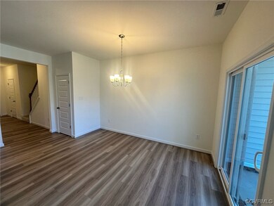 Unfurnished room featuring dark hardwood / wood-style flooring and a notable chandelier