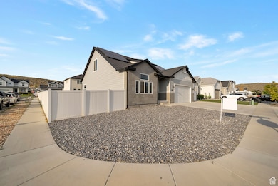 View of side of home featuring a residential view, concrete driveway, an attached garage, and solar panels