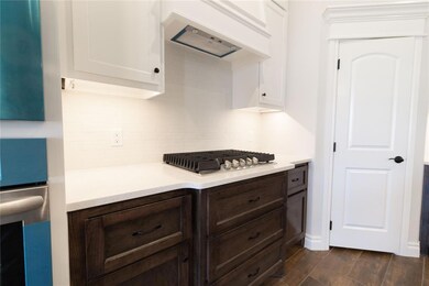 Kitchen with white cabinetry, premium range hood, 