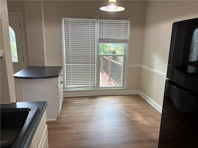 Unfurnished dining area featuring wood finished floors and baseboards