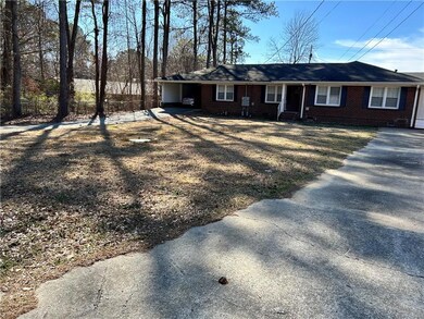 Single story home featuring driveway, brick siding