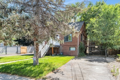 View of front of home featuring brick siding, concrete driveway, stairs, and a gate