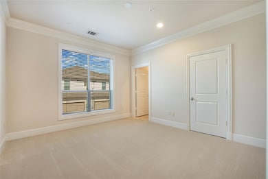 Carpeted spare room featuring crown molding