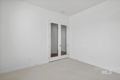 Unfurnished bedroom featuring french doors and carpet floors