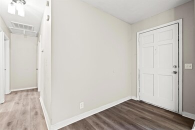 Foyer entrance with wood finished floors and baseboards